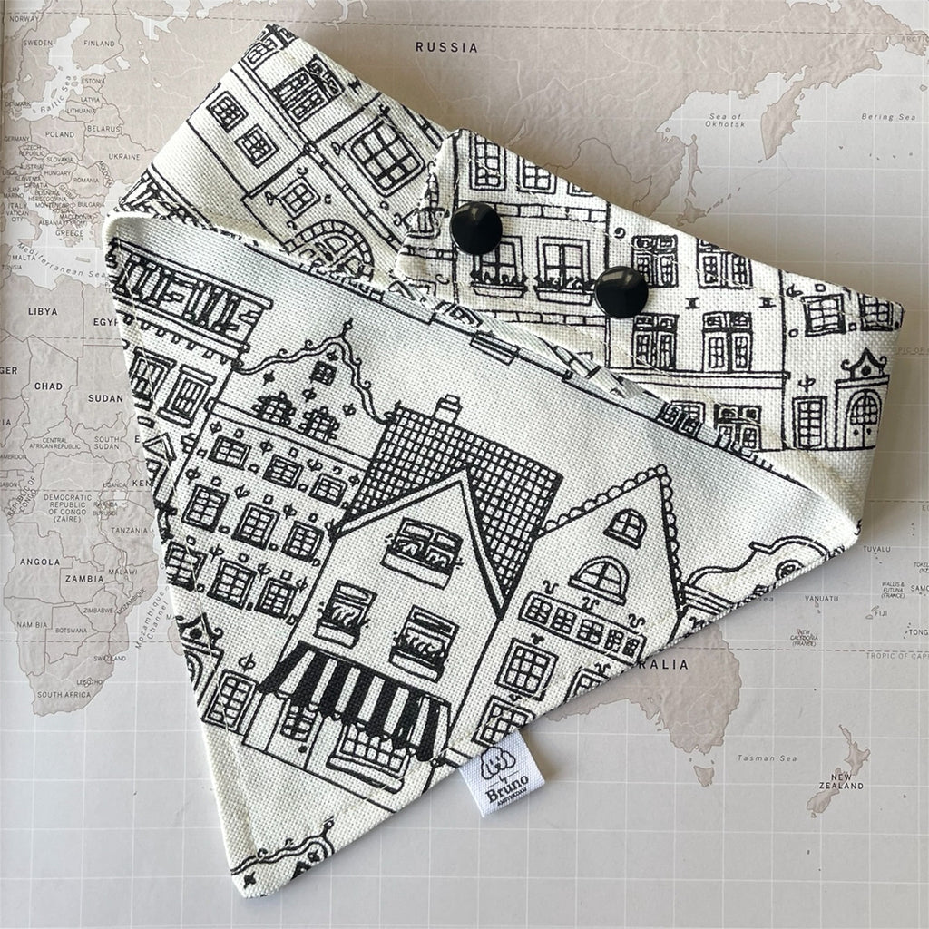 Back side of the dog bandana with Amsterdam print and two plastic buttons on a world map background.