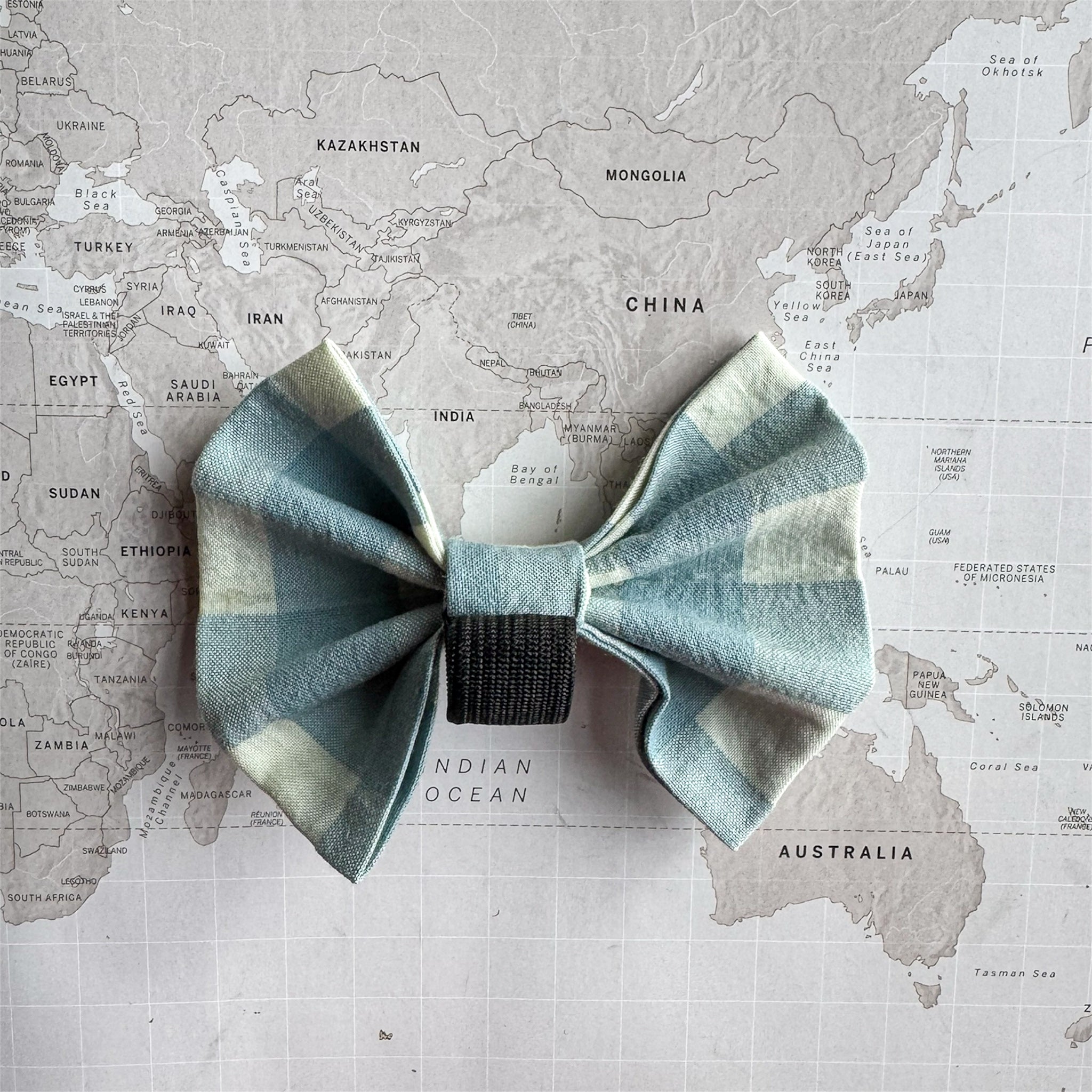 Back of the blue and white checkered bow tie with an elastic loop on a neutral background