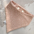 Warm apricot dog bandana with a soft, tonal scattered pattern on a world map background.