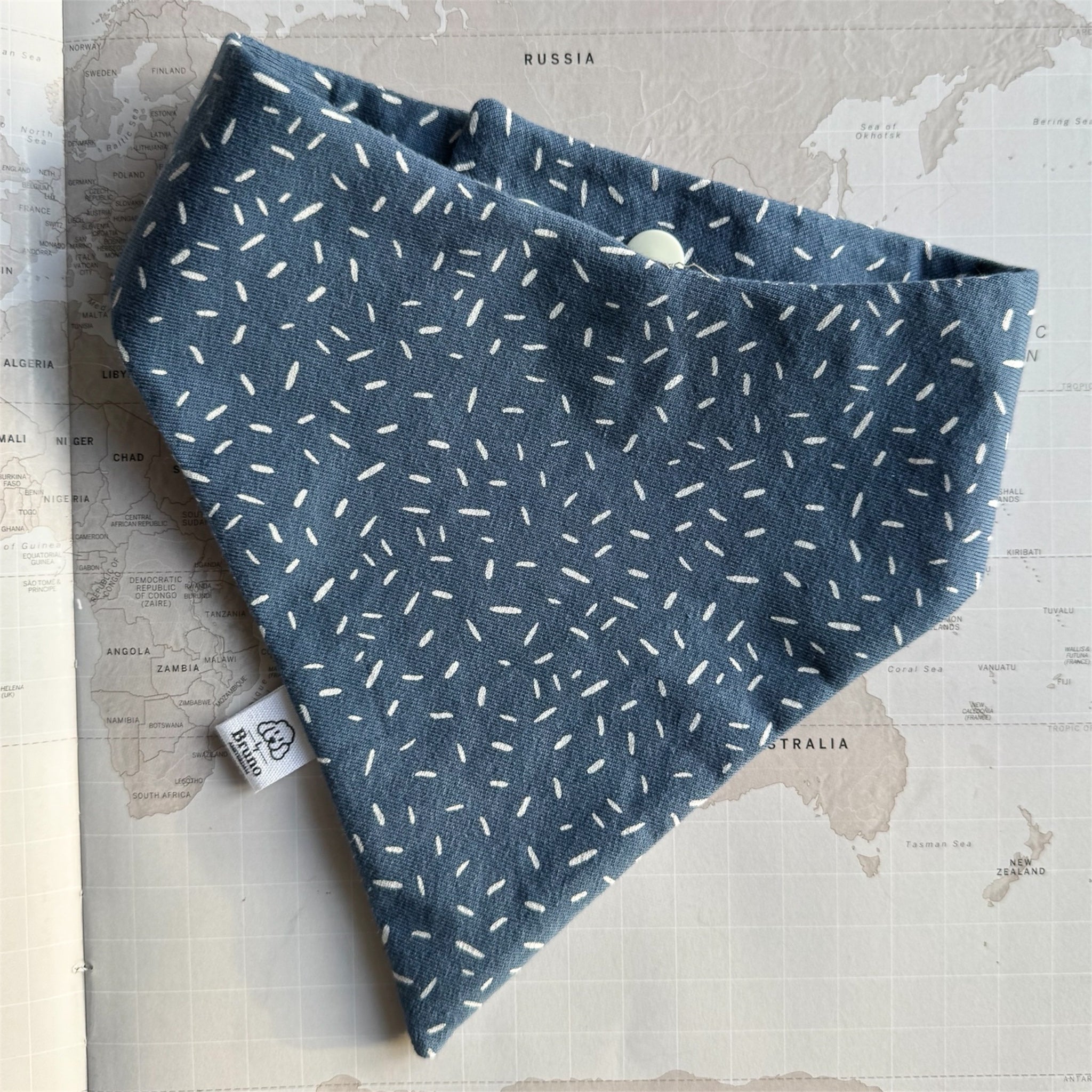 Deep dusty blue dog bandana scattered with fine white sprinkles.