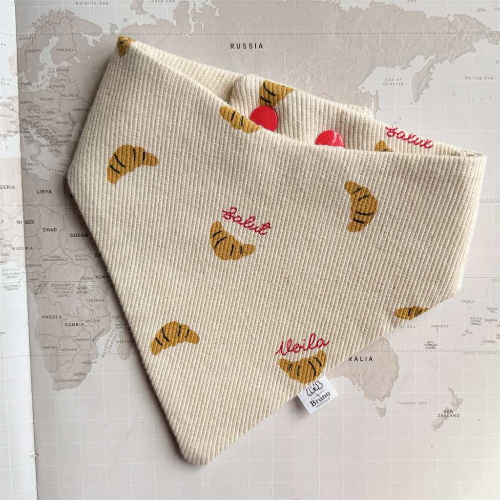 Dog bandana with croissants and French words in red.