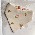 Dog bandana with croissants and French words in red.