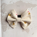 Dog bow with brown croissants and red words in French.