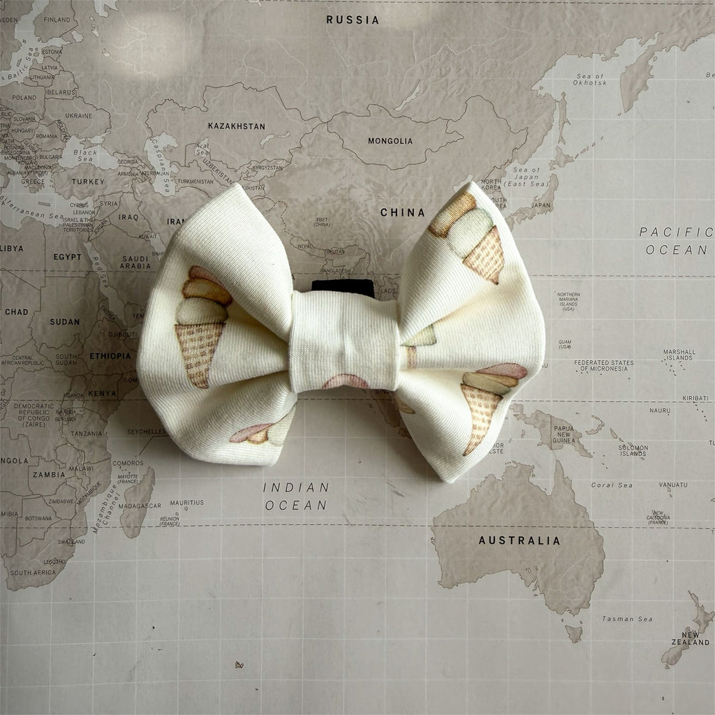 Lightweight dog bow inspired by Italian gelato and summer pastels on a world map background.
