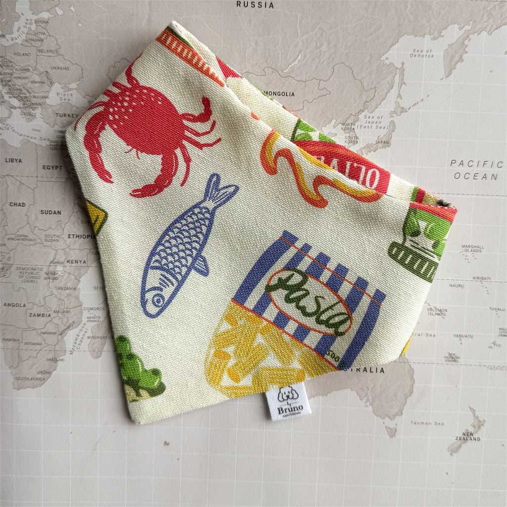 Ristorante al mare dog bandana with fish, crab and pasta on a world map background.